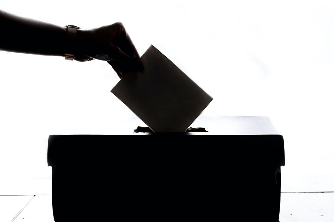 woman putting a ballot in a box