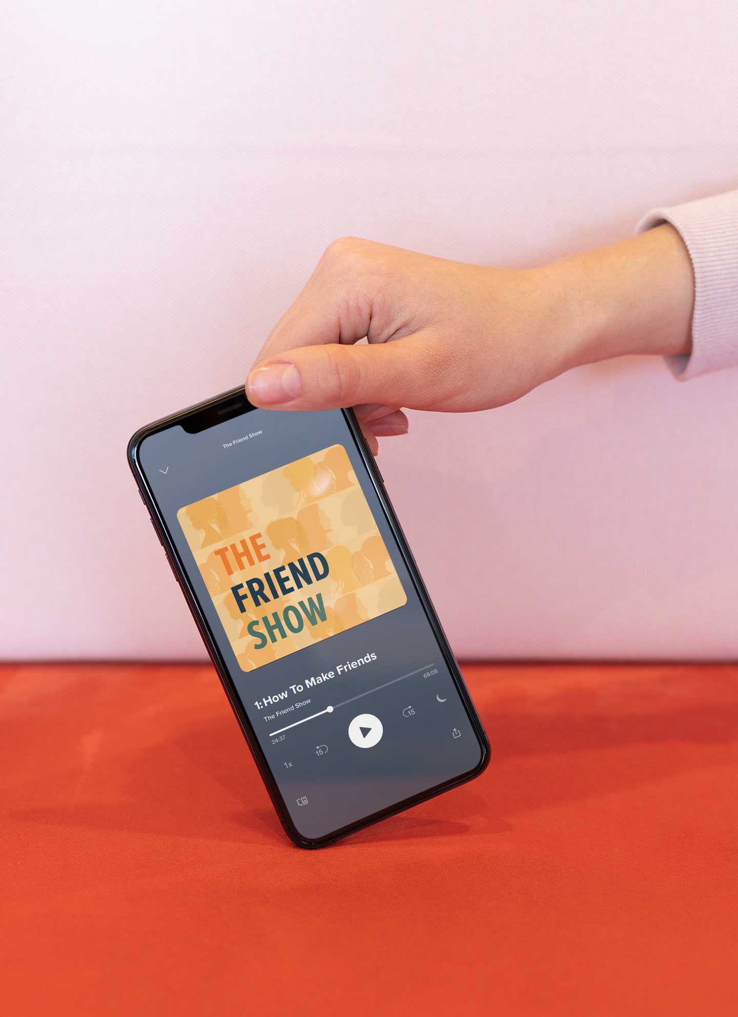 hand holding the corner of a phone with a podcast on the screen