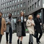 a group of professionals walking outside an office building in cold weather attire